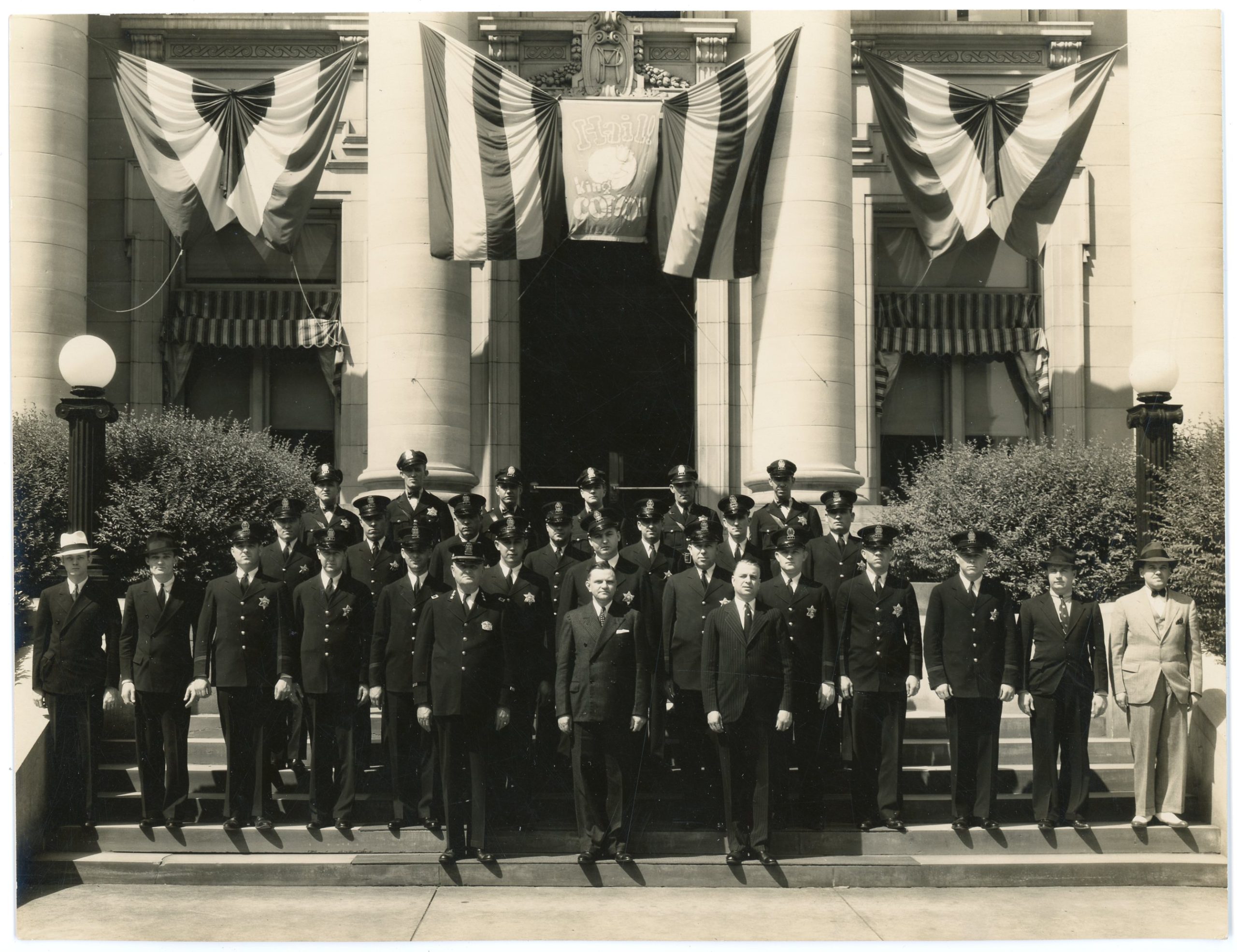 Group of police officers outside the Memphis Police Station at 128 Adams Avenue, Memphis, Tennessee, undated (1930s). The photograph was taken during Cotton Carnival. Commissioner of Public Safety Clifford Davis is in the middle of the front row. Photographer: Tuttle, Bureau of Identification, Memphis Police.  How Black Memphis music resists police with the Blues.